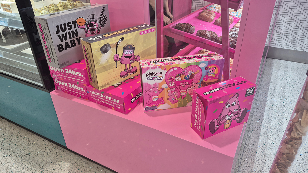 Assorted Pinkbox Doughnut cartons on a shelf