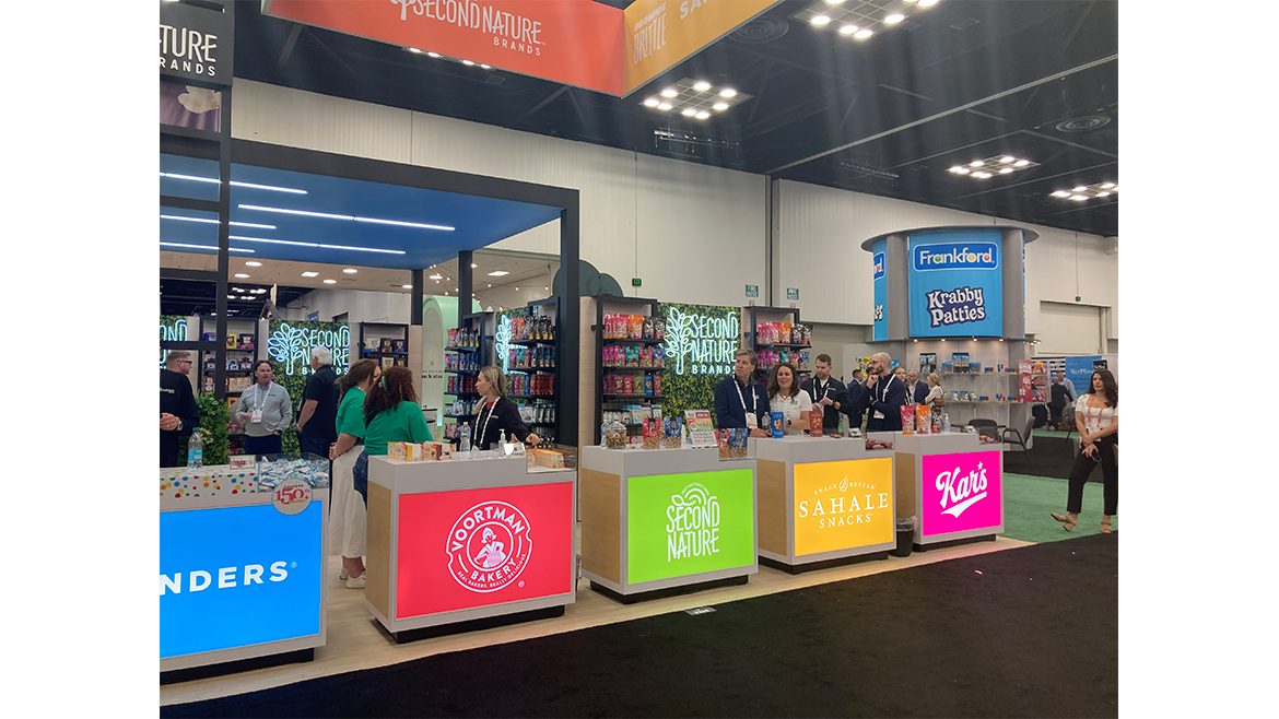 The Second Nature Brands booth at the 2025 Sweets & Snacks Expo with brightly colored banners for each of its brands.