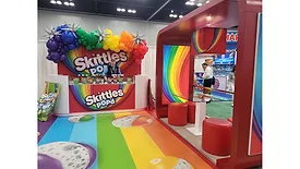 The Skittles Pop’d booth at the 2025 Sweets & Snacks Expo, which is brightly colored.