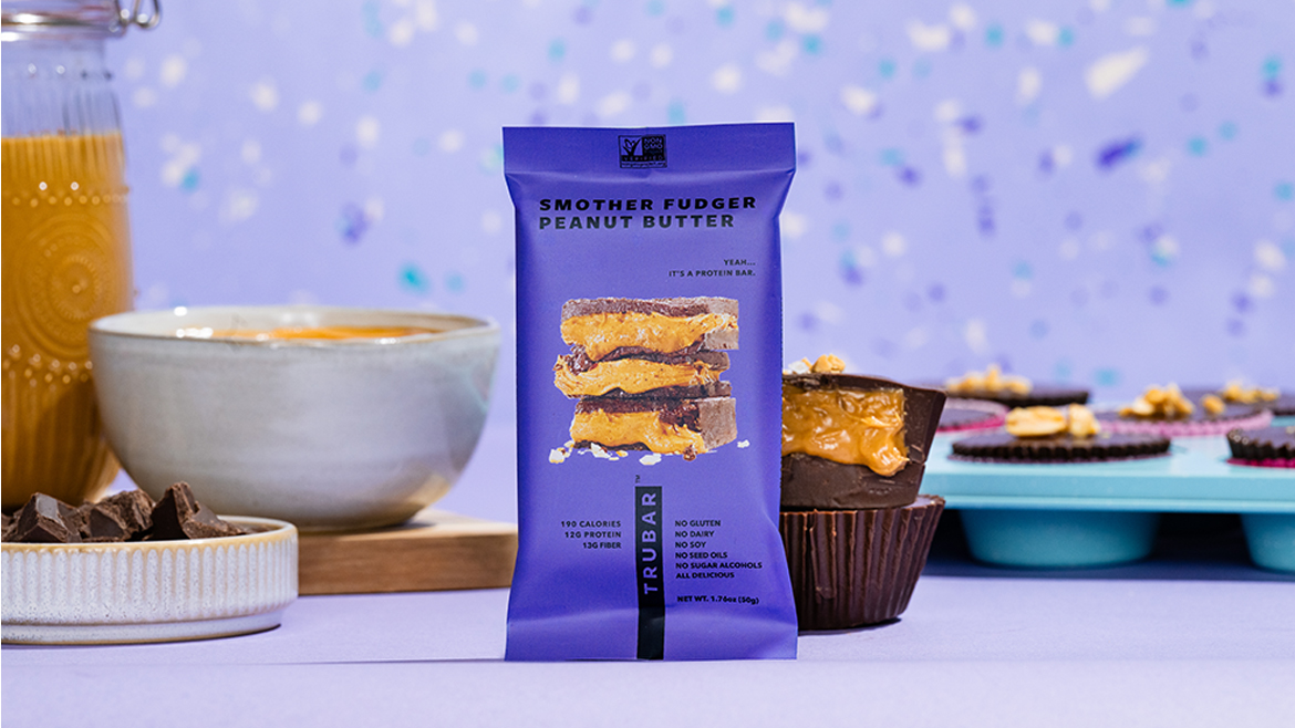 The item shown is a TRUBAR Smother Fudger Peanut Butter plant-based protein bar. 