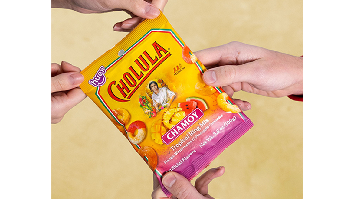 A purple and yellow bag of Chamoy gummies with hands pictured holding it.