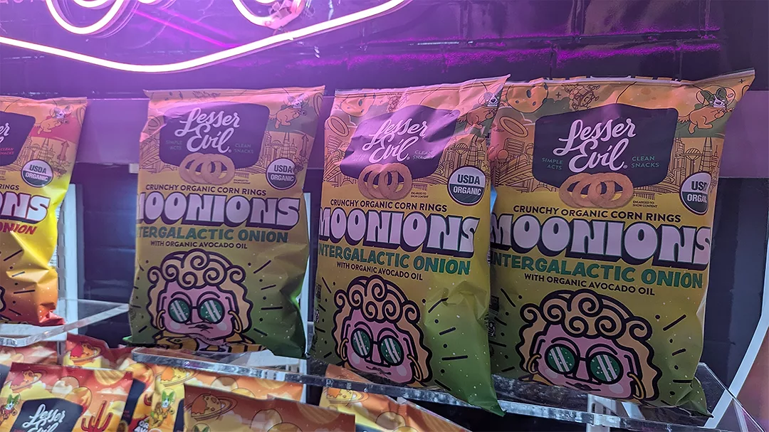 Bags of LesserEvil Moonions snacks at tradeshow booth