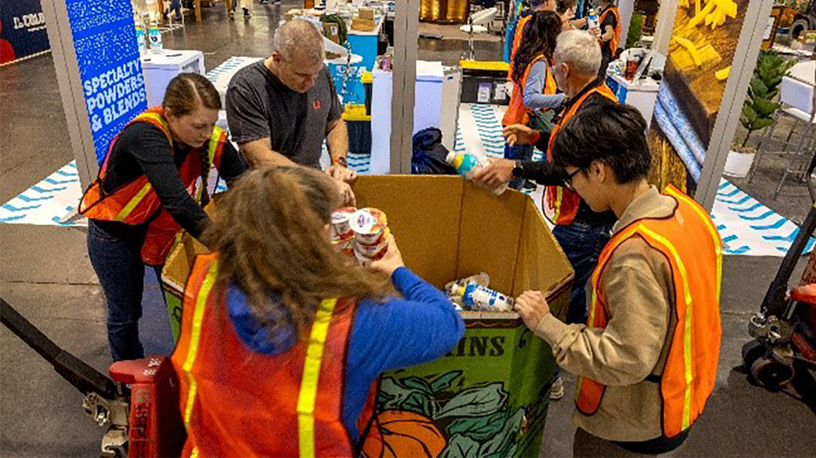 Group of young people in orange reflective vests sorting food donations