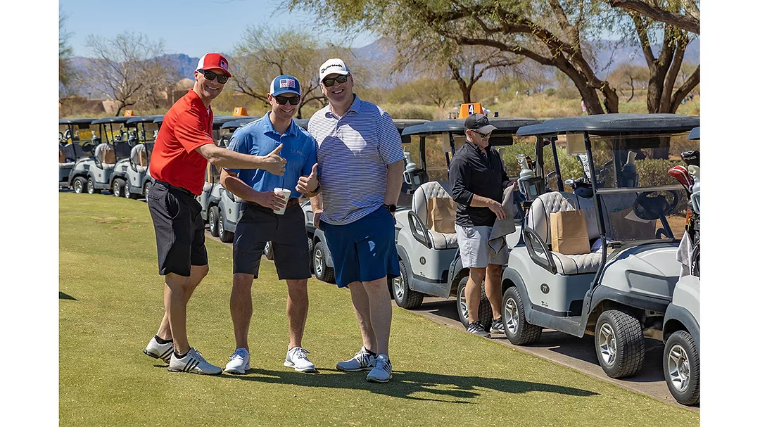 This image shows a moment from a charity golf tournament, highlighting community support and outdoor activity.