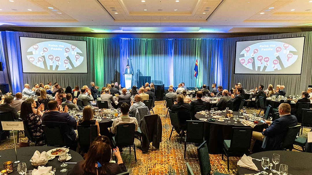 This image captures a moment at a professional conference or gala luncheon.