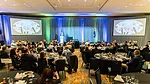 This image captures a moment at a professional conference or gala luncheon. 
