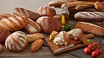This image features a selection of rustic artisan breads, including crusty boules, baguettes, and loaves. 