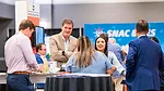 This image shows a scene from a trade show, likely focused on the snack industry, based on the branding visible in the background. 
