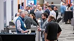 This image depicts a professional trade show, specifically the SNX event organized by SNAC International for the snack industry. 
