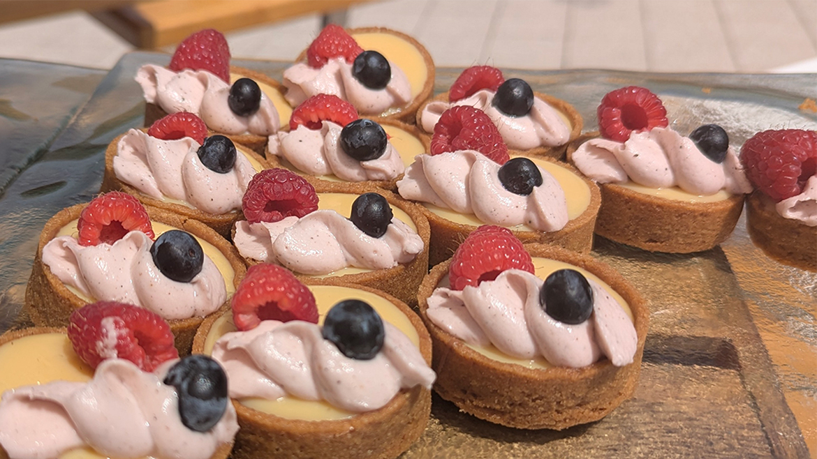 Several fruit tarts on a wooden tray