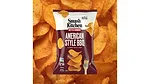 A brown and white bag of Smash Kitchen Kettle Cooked American Style BBQ chips, with chips in the background.
