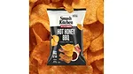 A black and white bag of Smash Kitchen Kettle Cooked Hot Honey BBQ chips, with chips in the background.