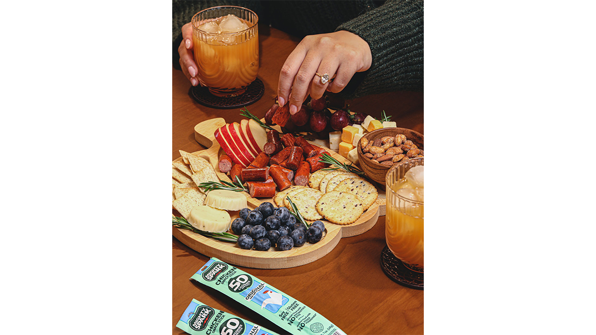 Table with charcuterie tray, packs of Mighty Spark meat sticks, and drinks