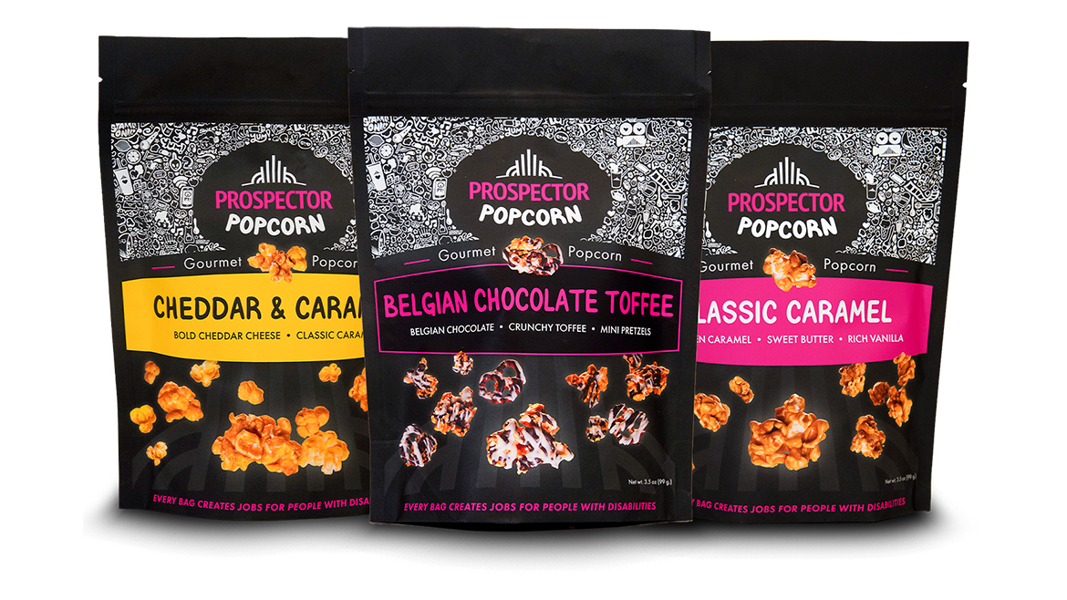 These gourmet snack bags feature artisanal Prospector Popcorn varieties including Cheddar & Caramel, Belgian Chocolate Toffee, and Classic Caramel.