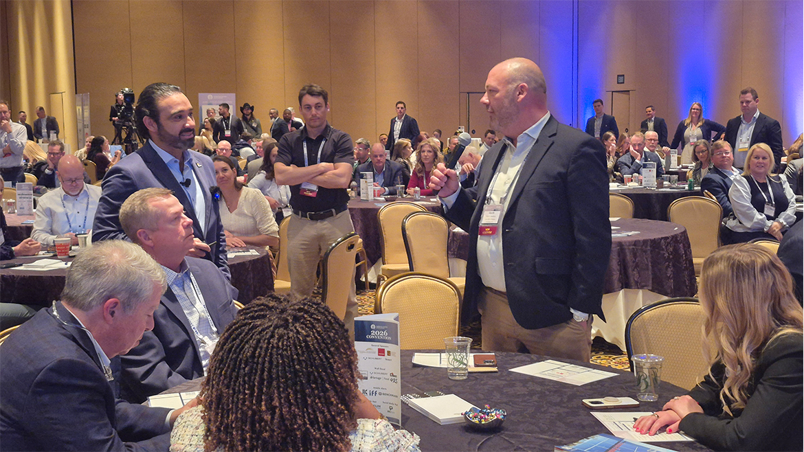 Man standing with mic questioning another man