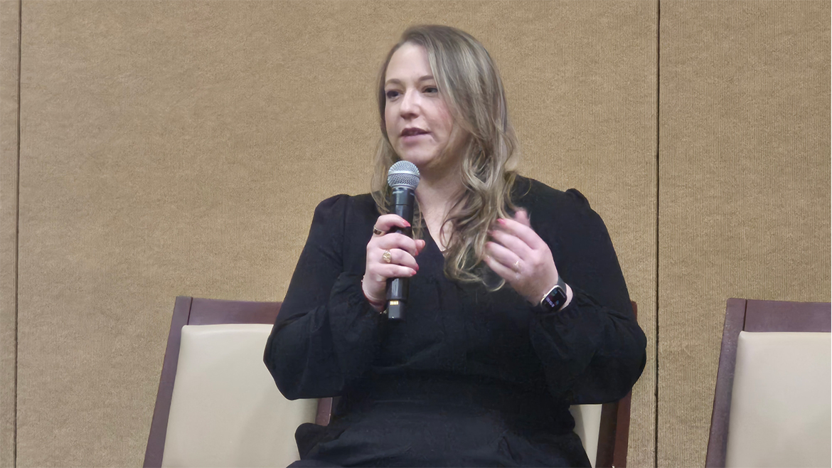 Woman holding mic while sitting down
