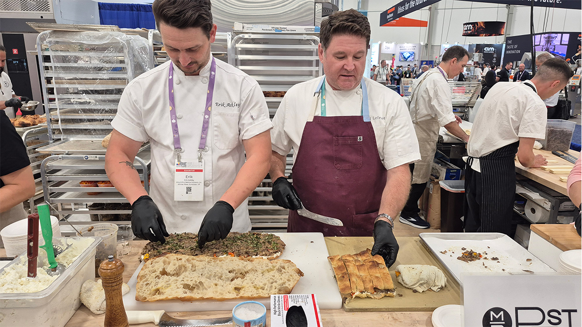 Two chefs preparing sandwiches at counter
