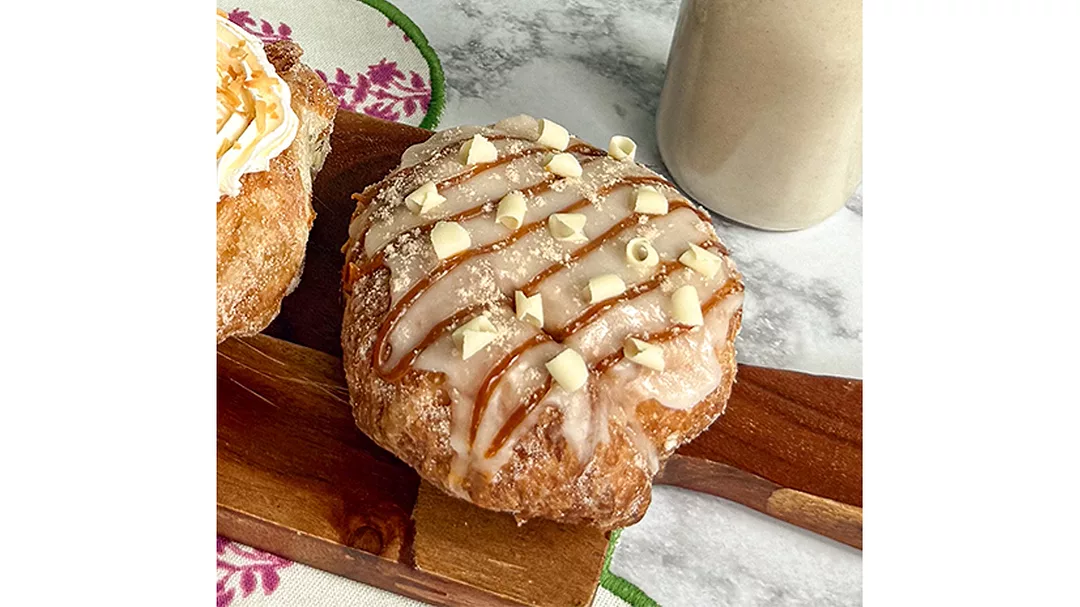 Horchata doughnut on table next to bottle of horchata