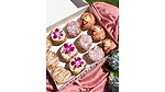 Carton of assorted doughnuts on a pink tablescape
