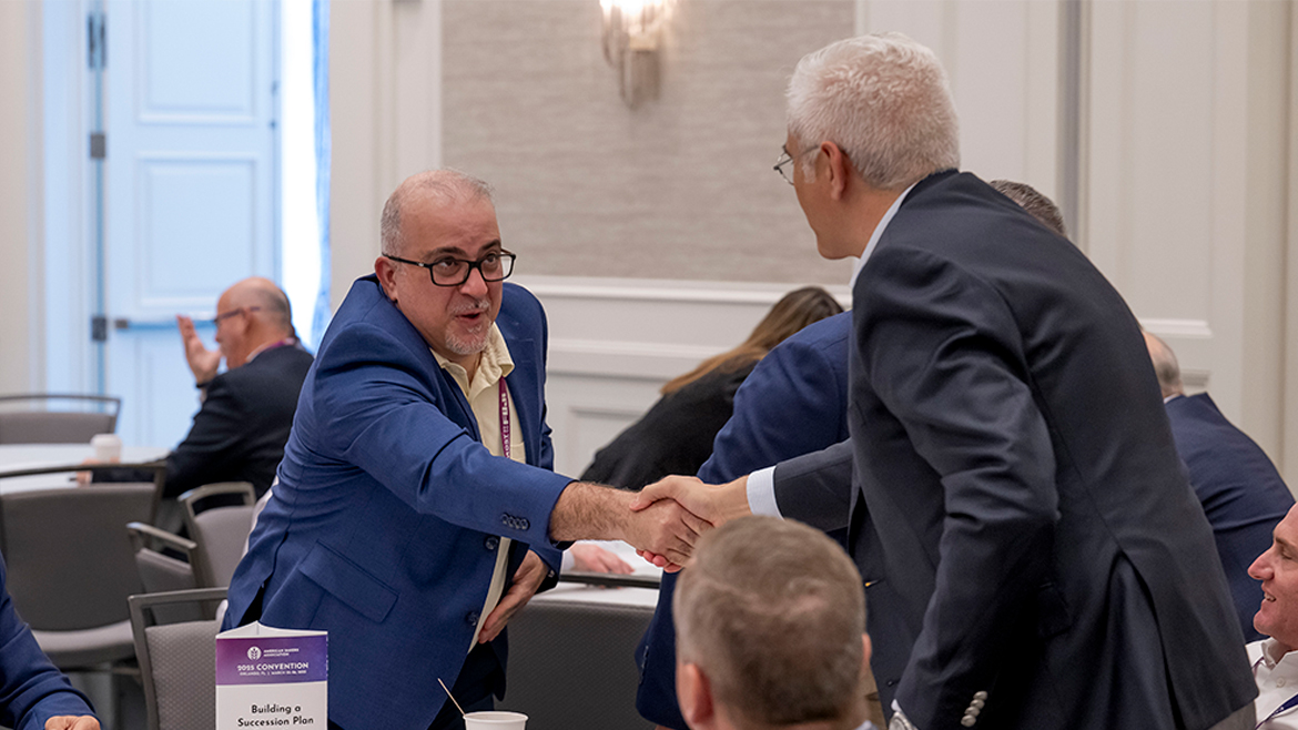 This image shows a scene of business professionals interacting at a conference.