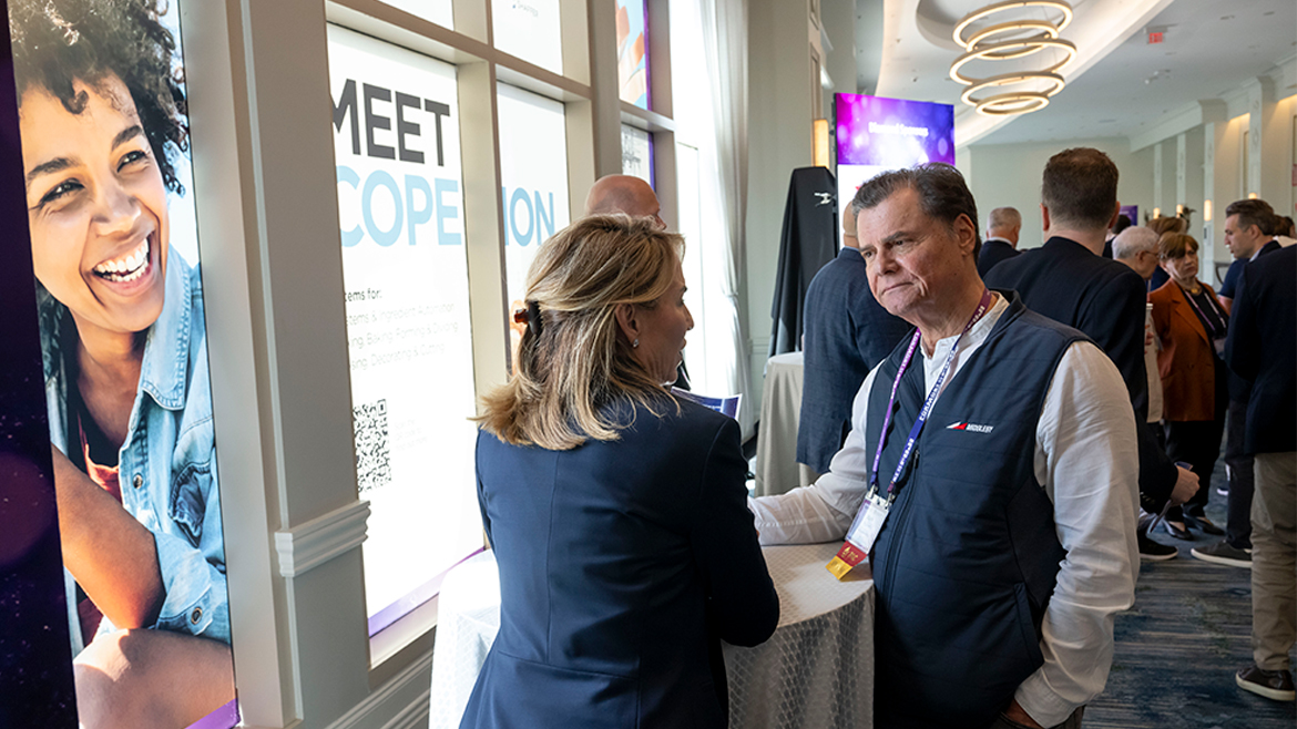 A man and a woman dressed in business attire networking at ABA Convention 2025.