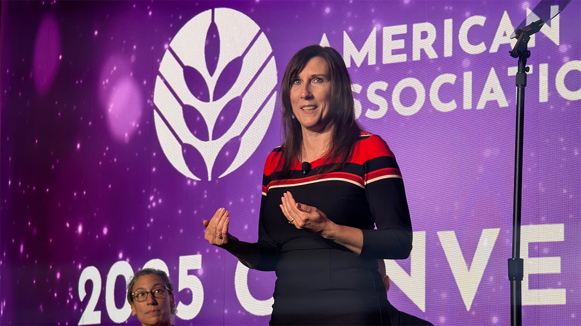 Anne-Marie Roerink, wearing a black sweater with red and white stripes, speaks at ABA Convention 2025.