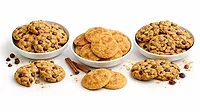Three piles and dishes of different types of cookies on a white background Three piles and dishes of different types of cookies on a white background