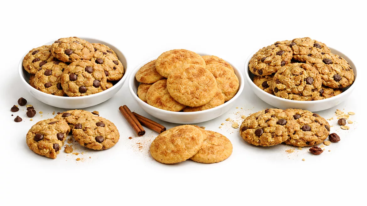 Three piles and dishes of different types of cookies on a white background