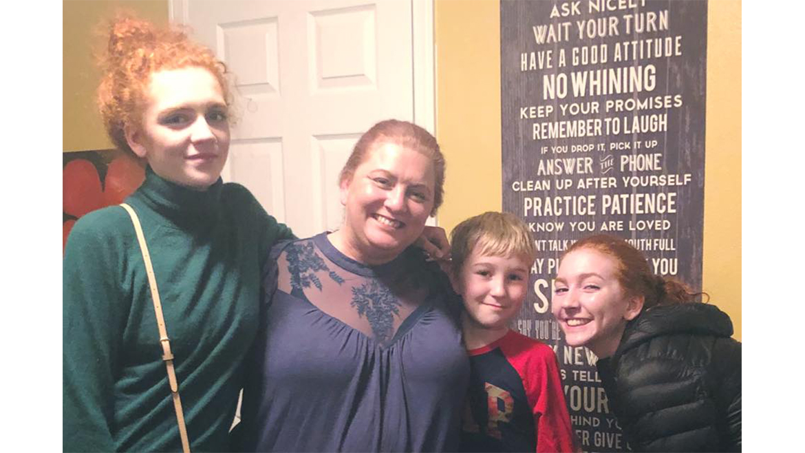 Two adult women and two children side by side and smiling