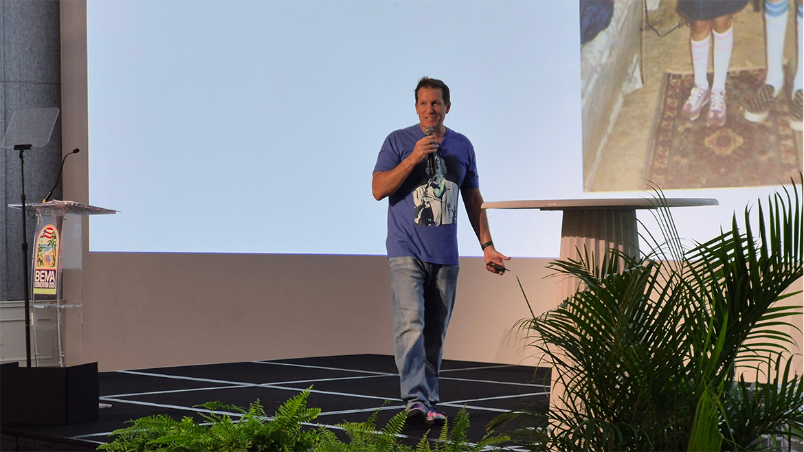 A man wearing a blue t-shirt and jeans presents a panel at BEMA 2025.