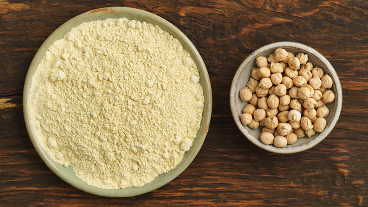 Bowl of flour and bowl of chickpeas on wooden table