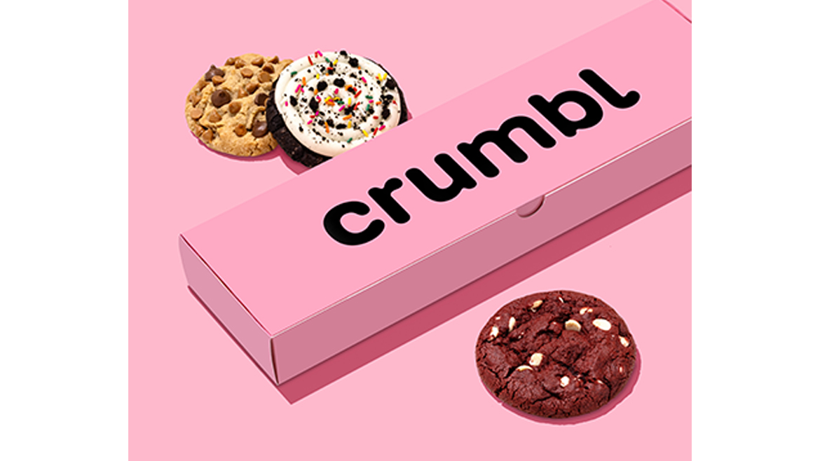 Crumbl box and three cookies on pink background