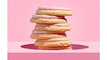 Stack of Crumbl pink frosted sugar cookies over pink background