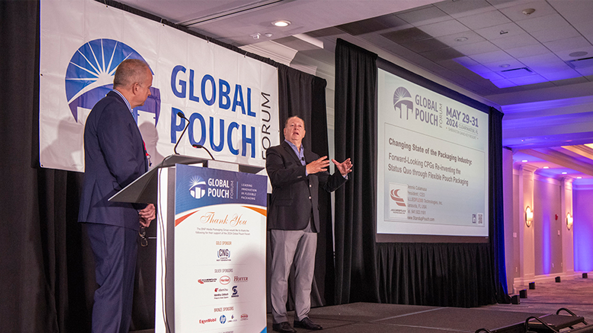 Two men stand on a podium presenting at the Global Pouch Forum.