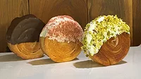 Three round sweet baked goods with different coatings on table