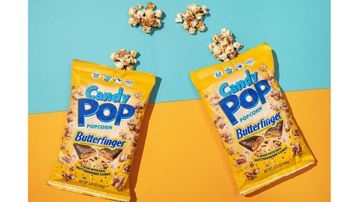Two yellow bags of Butterfinger CandyPop popcorn, with some out of the bag, against a yellow and blue background.