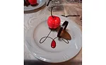 Plated dessert featuring a cherry jam-filled vanilla mouse  cherry accompanied by a chocolate mousse.